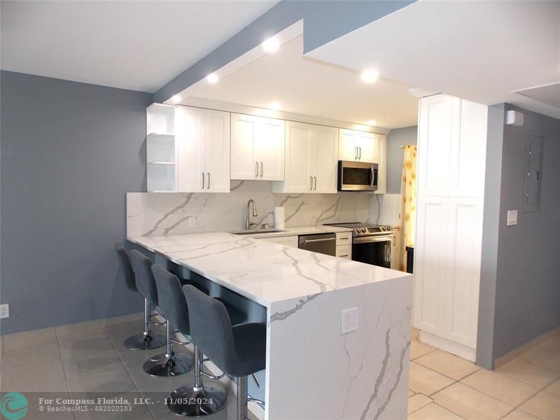 a kitchen with kitchen island a sink table and chairs