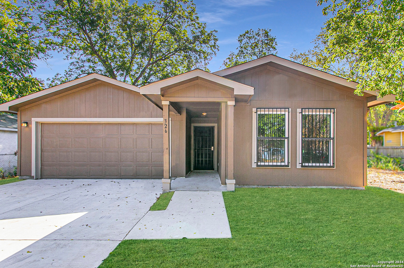 a front view of a house with a yard and garage