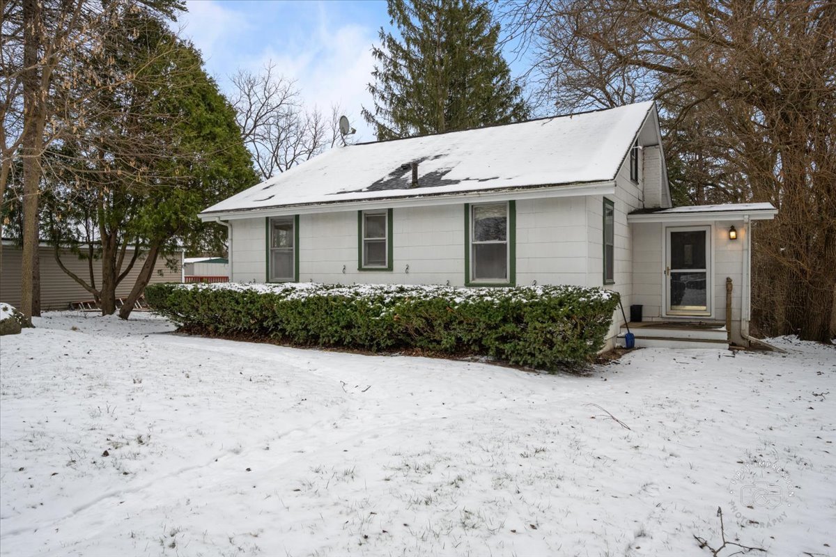 a view of a white house with a yard and large tree