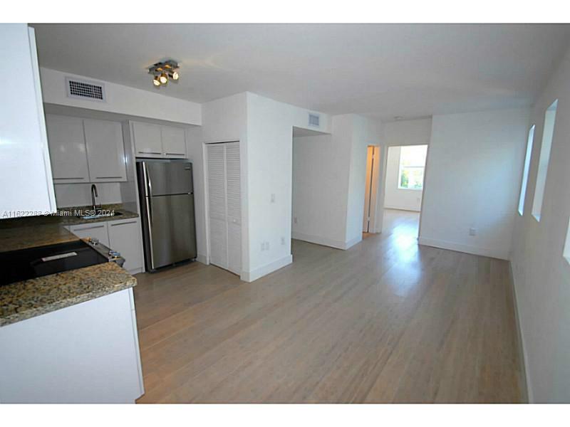 a kitchen with stainless steel appliances granite countertop a refrigerator and a stove top oven