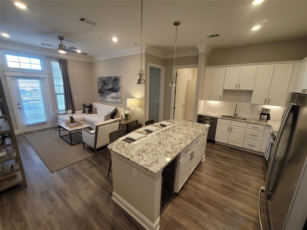 a large white kitchen with sink refrigerator and cabinets