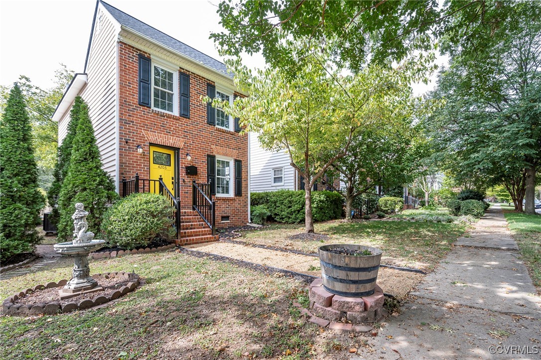 a backyard of a house with fountain plants and large tree