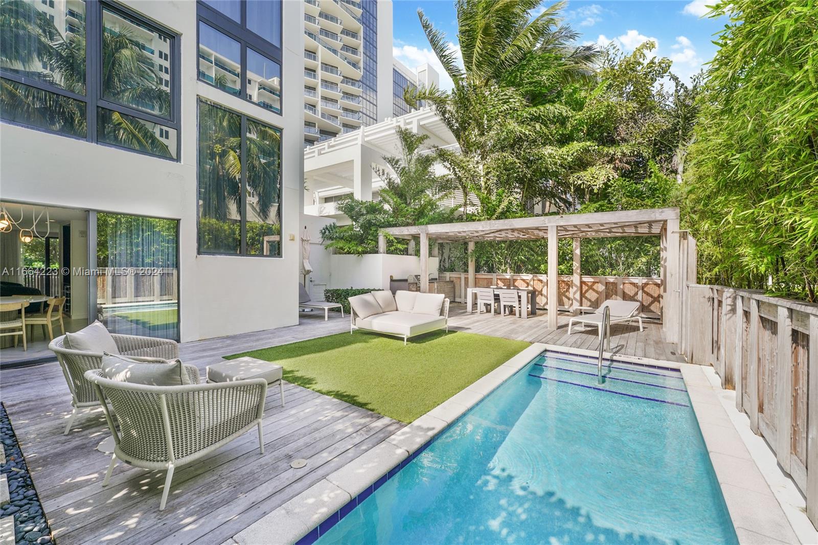 a view of a house with backyard swimming pool and sitting area