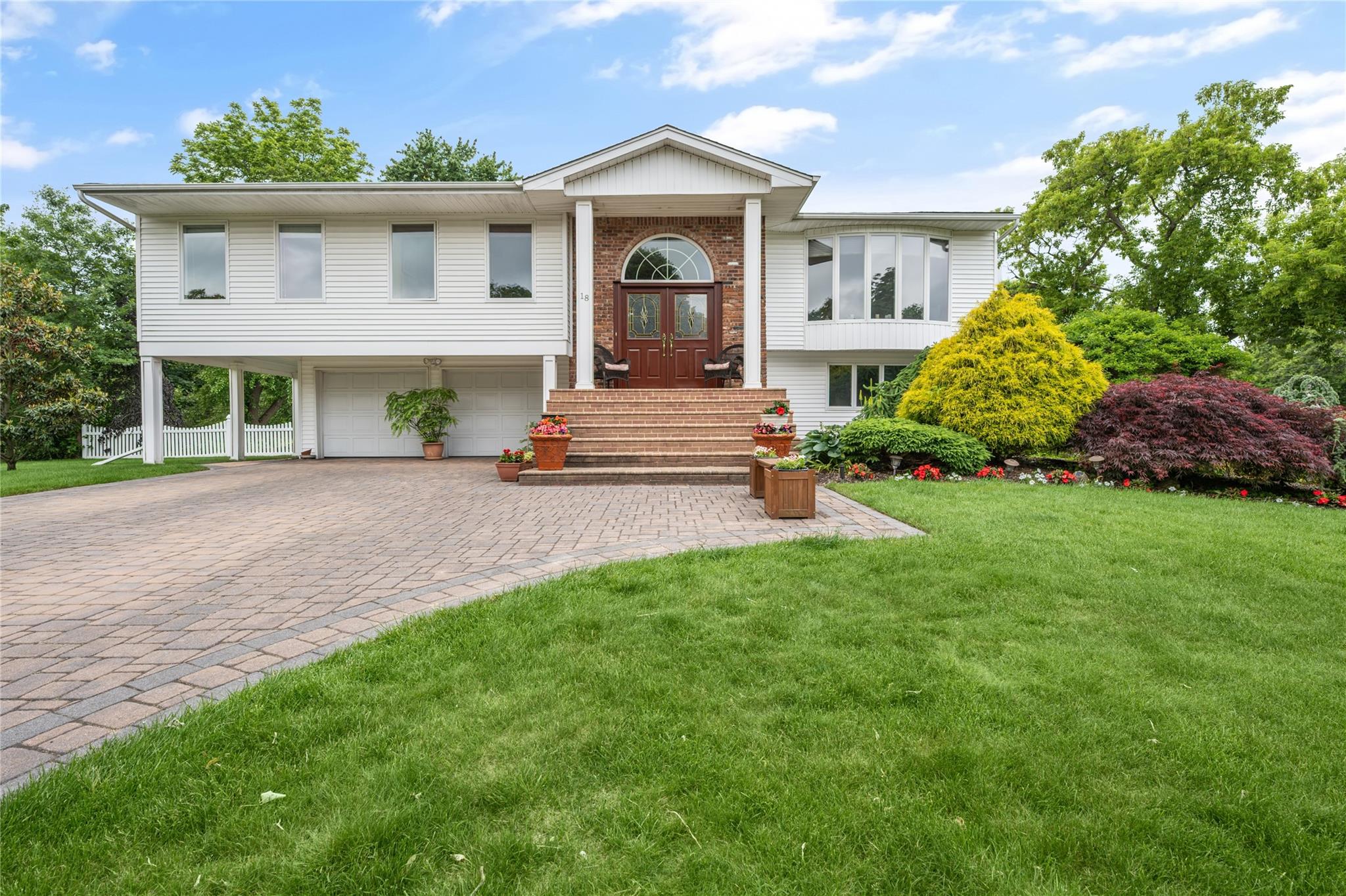 a front view of a house with a yard and potted plants