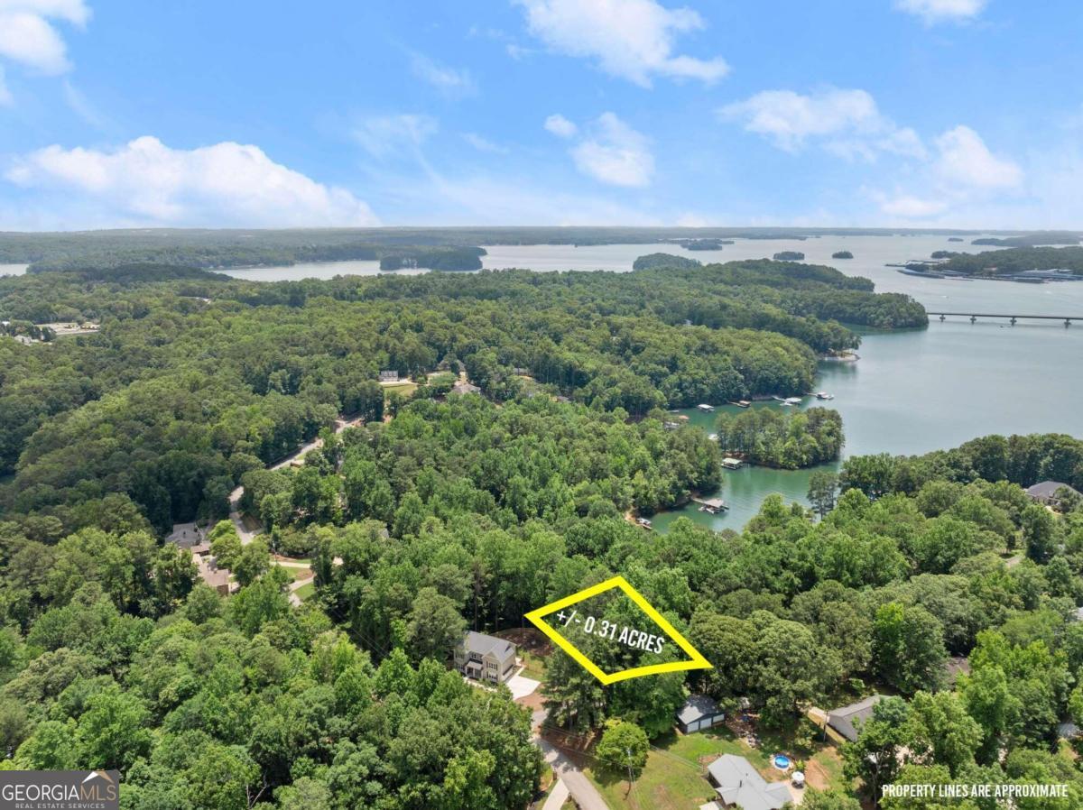 an aerial view of a house with a yard and lake view