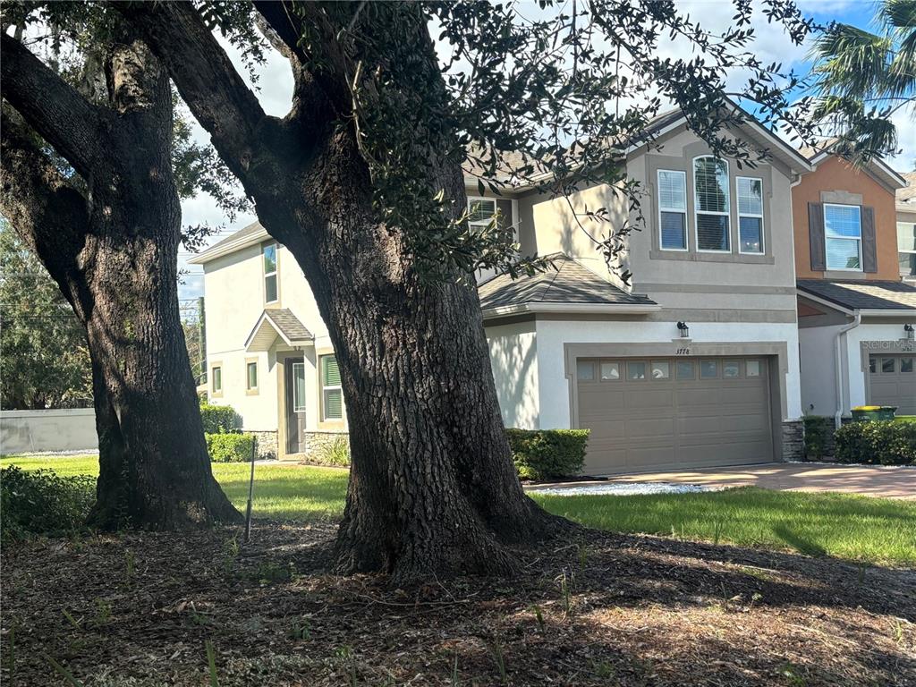 a front view of a house with a garden and trees