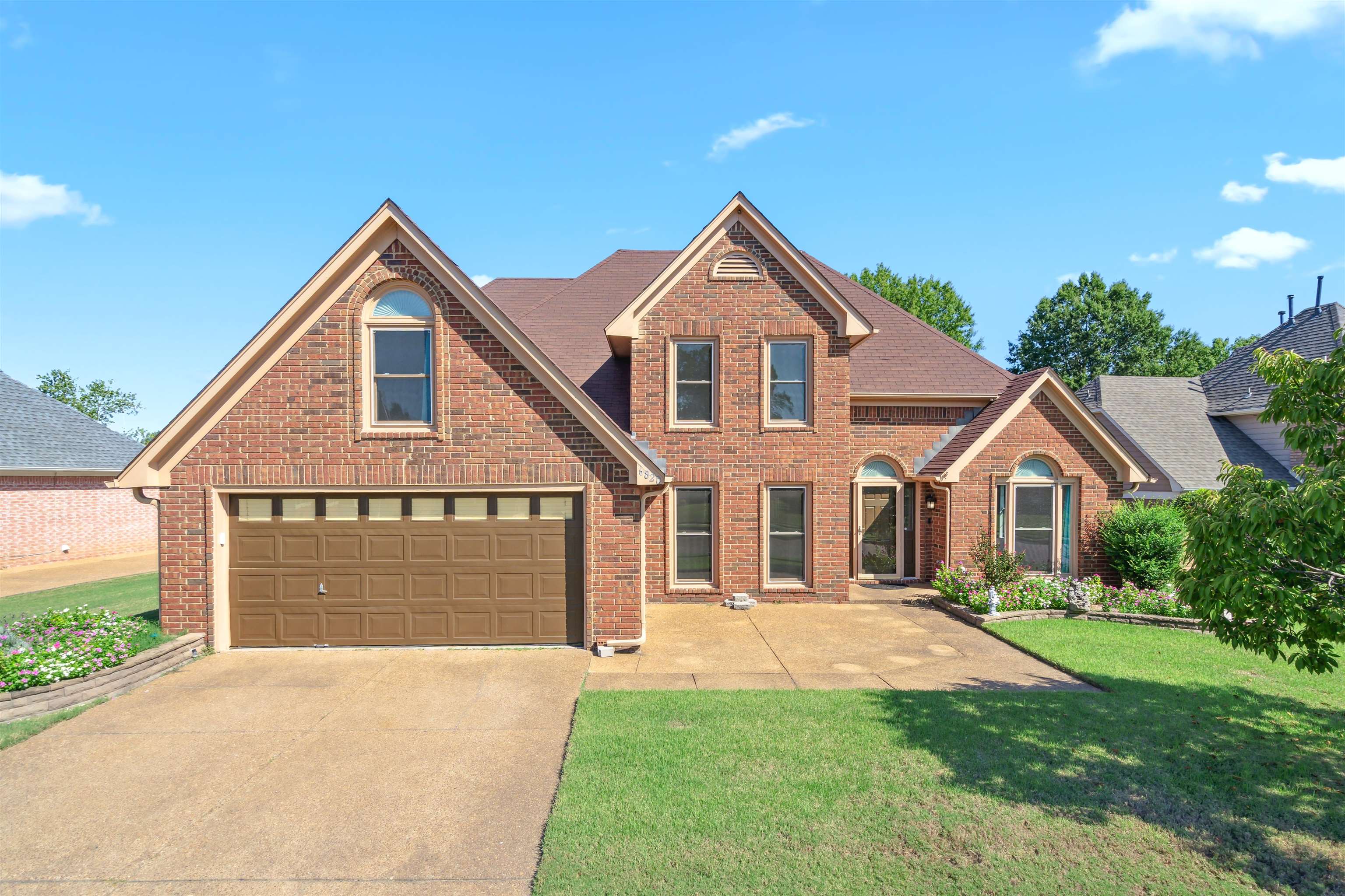 View of property featuring a garage and a front yard