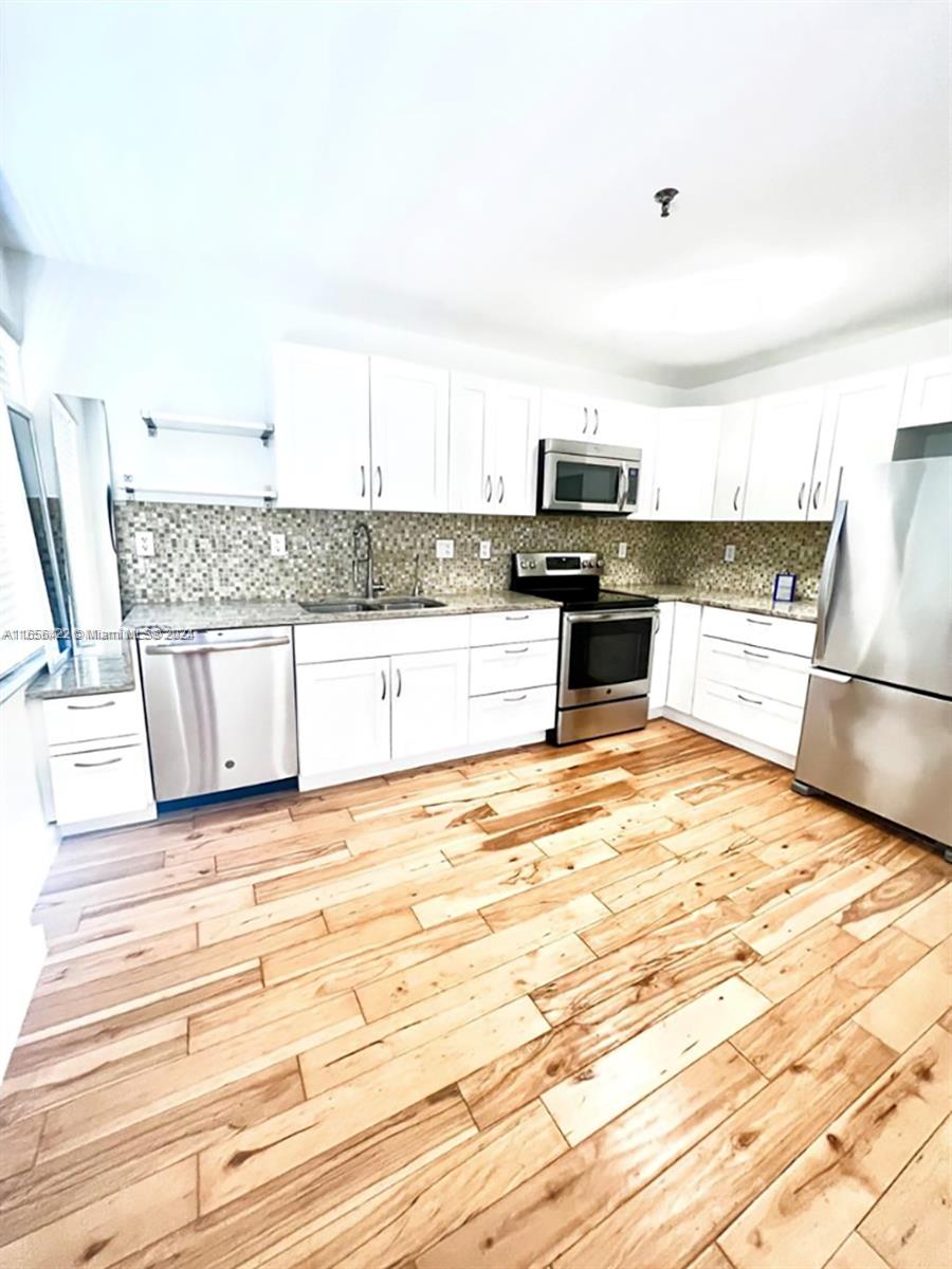 a kitchen with granite countertop a stove and a refrigerator