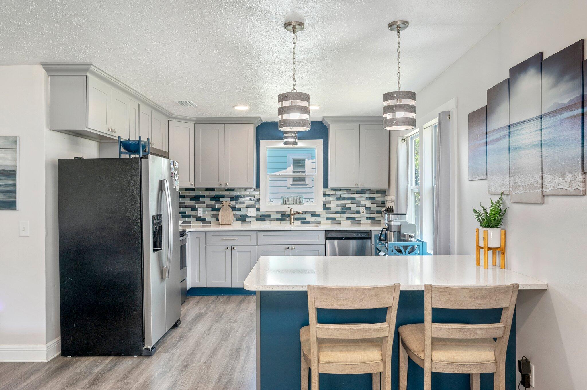 a kitchen with kitchen island granite countertop a sink a center island and stainless steel appliances