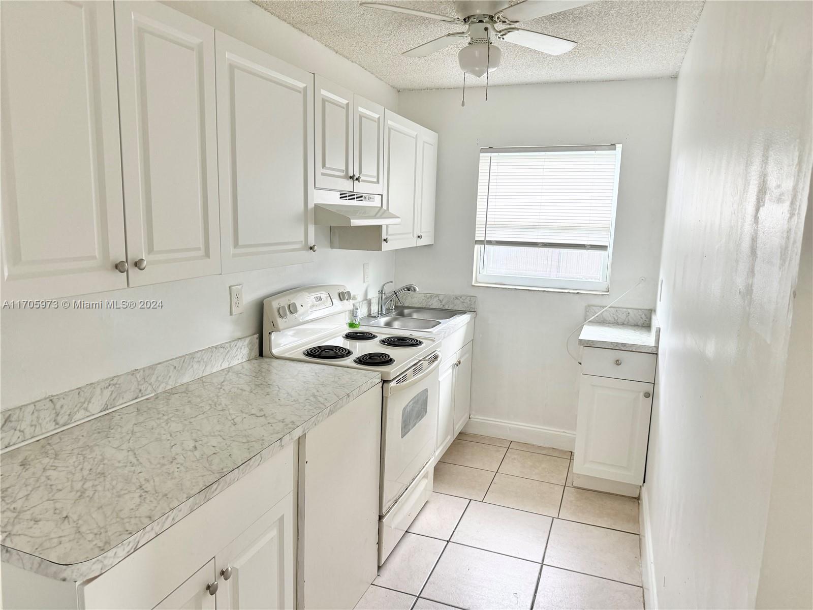 a kitchen with a sink cabinets and window