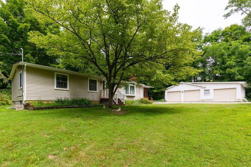 View of front of property featuring an outdoor structure, a garage, and a front lawn