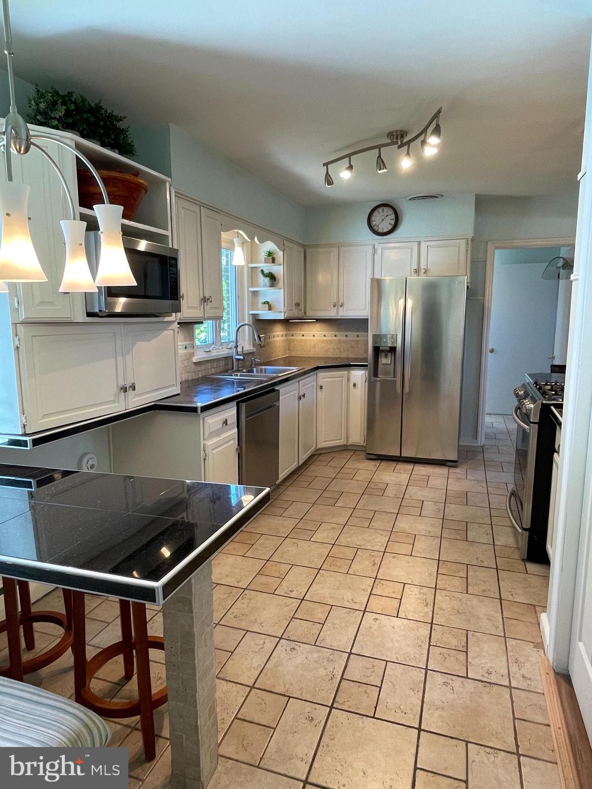 a kitchen with stainless steel appliances granite countertop a refrigerator and a stove top oven