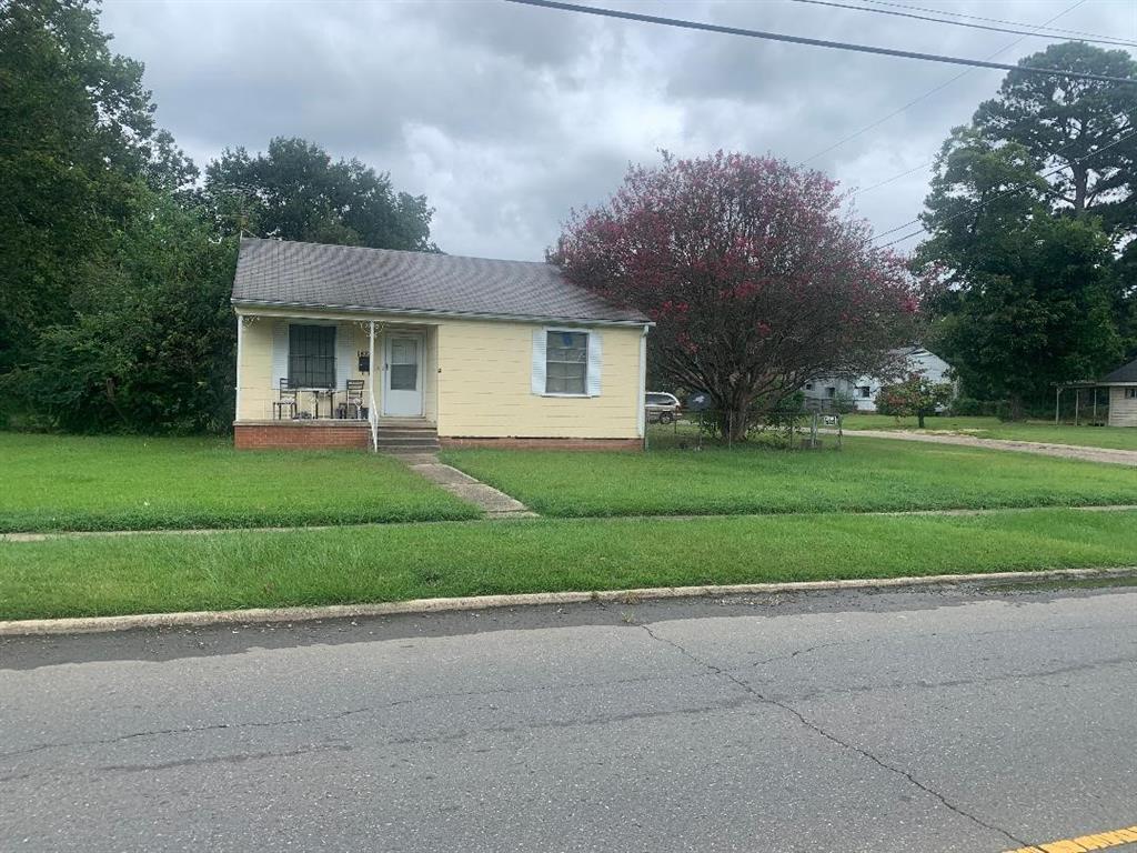 a front view of a house with a yard and trees