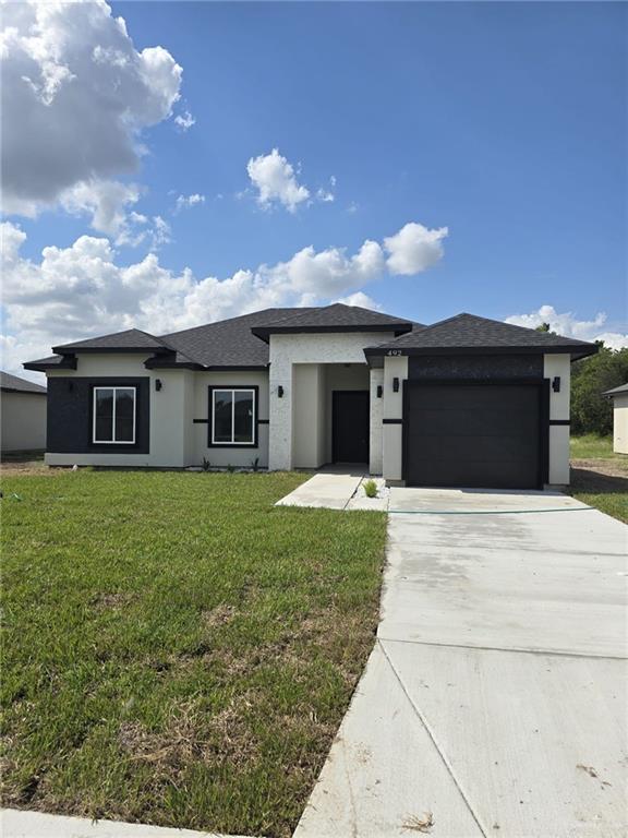 Prairie-style home featuring a garage and a front lawn