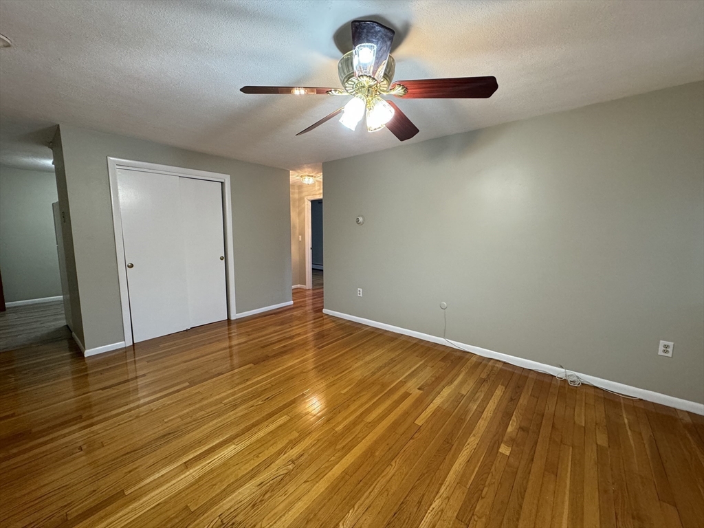 a view of empty room with wooden floor