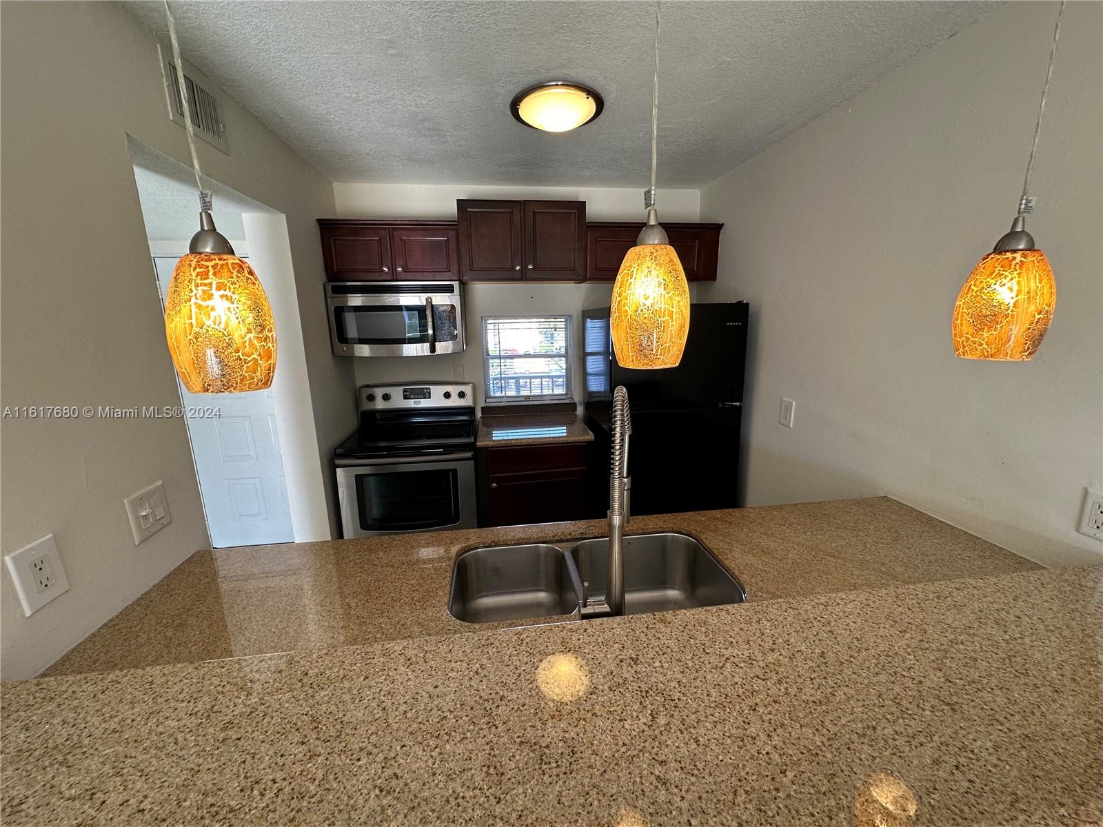 a kitchen with stainless steel appliances granite countertop a sink and a microwave