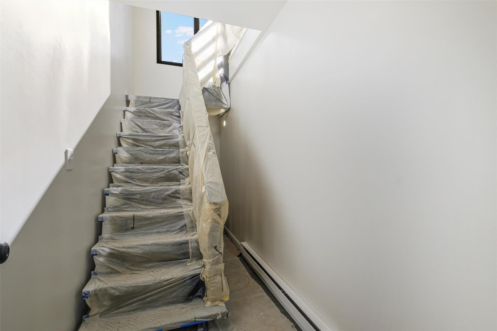 Staircase with concrete flooring and a baseboard radiator