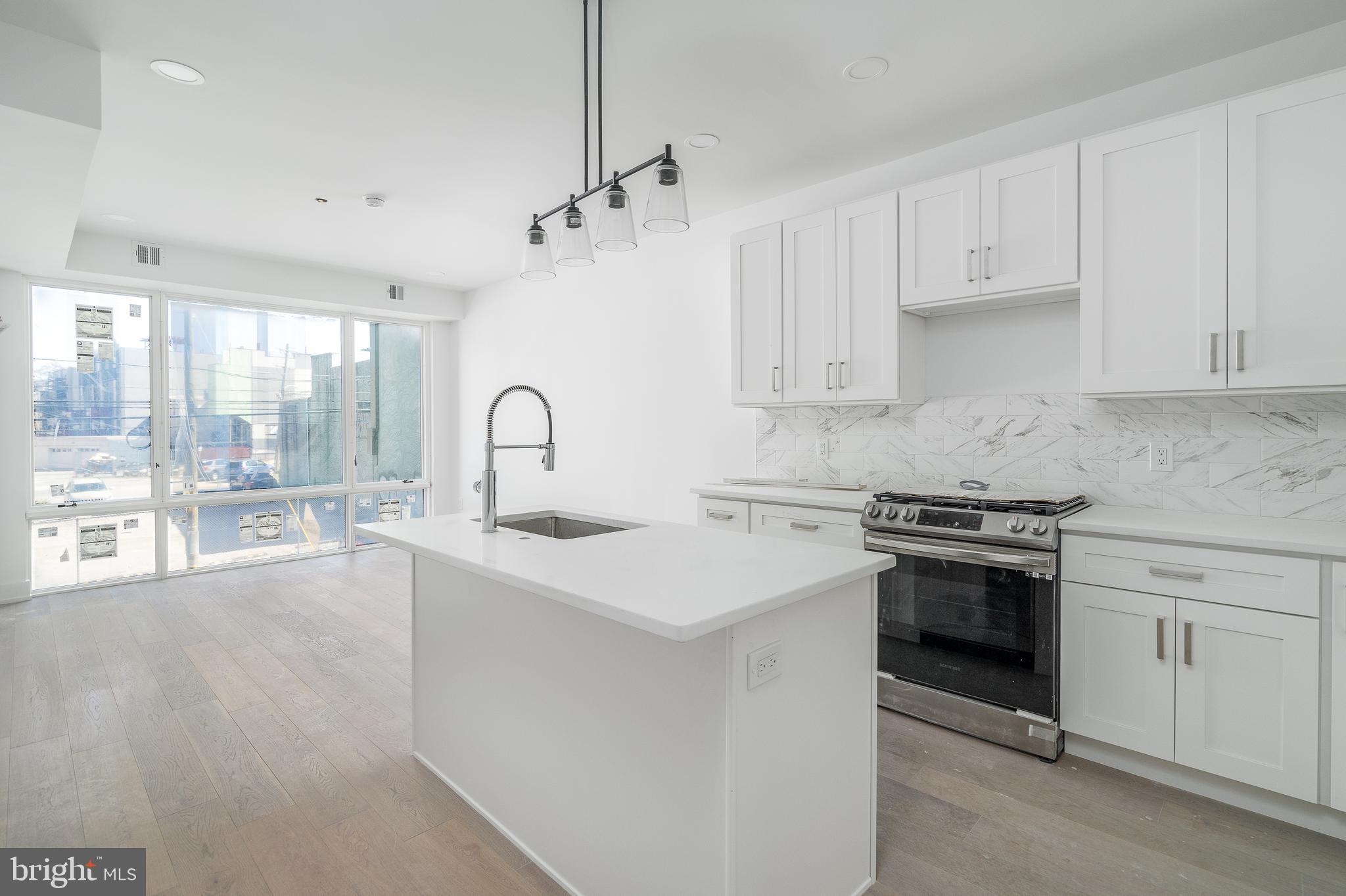 a kitchen with granite countertop a sink stove and refrigerator