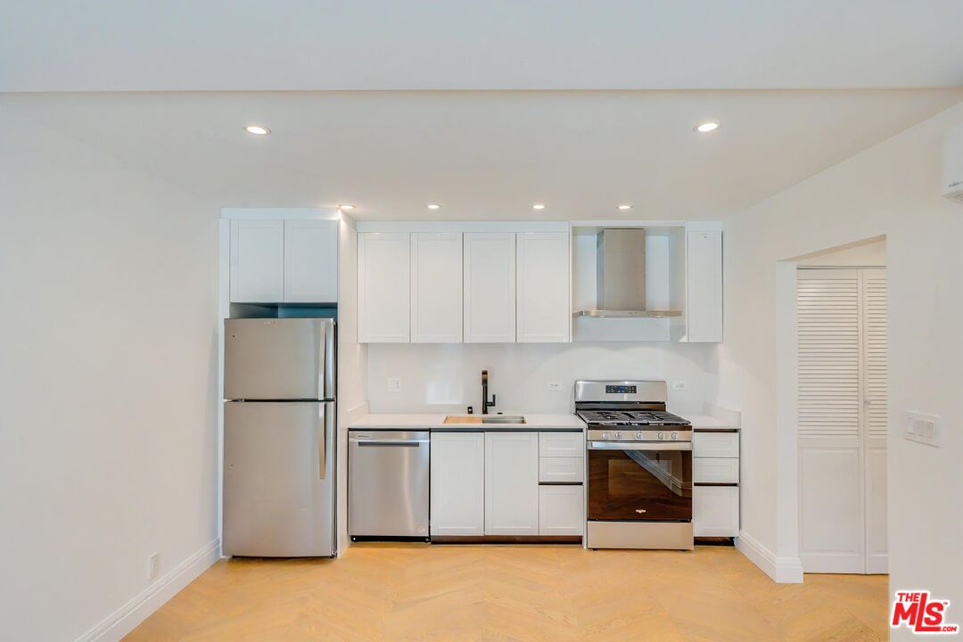 a kitchen with a refrigerator and a stove top oven