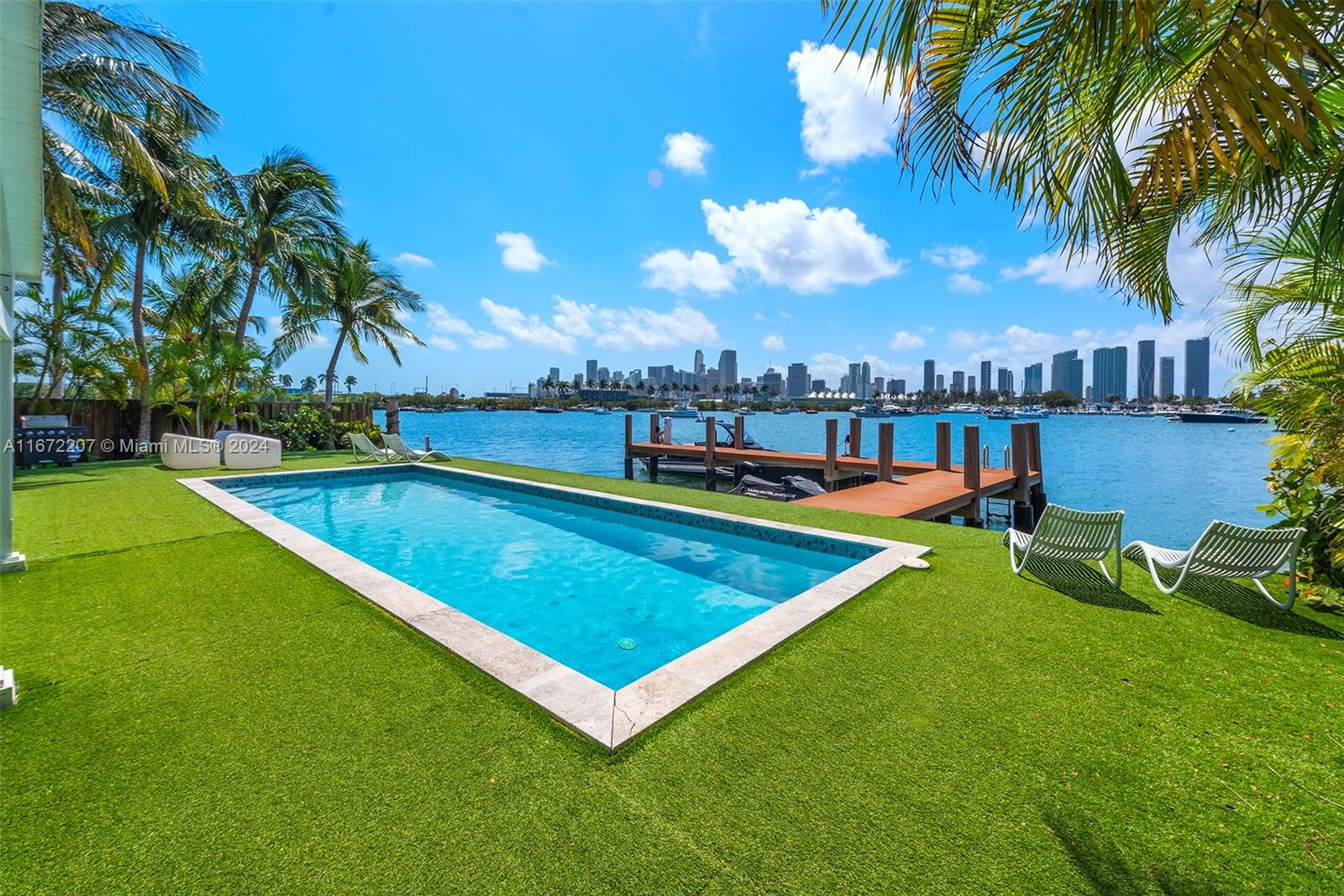 a view of a swimming pool with a bench and lawn chairs