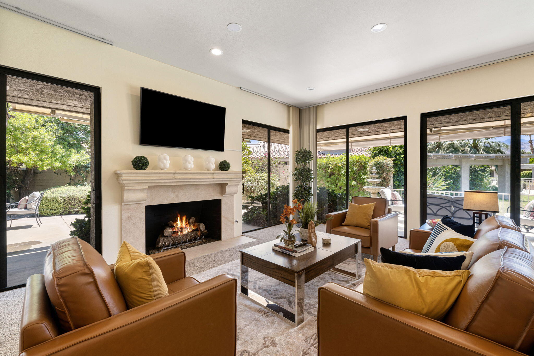 a living room with furniture fireplace and floor to ceiling windows