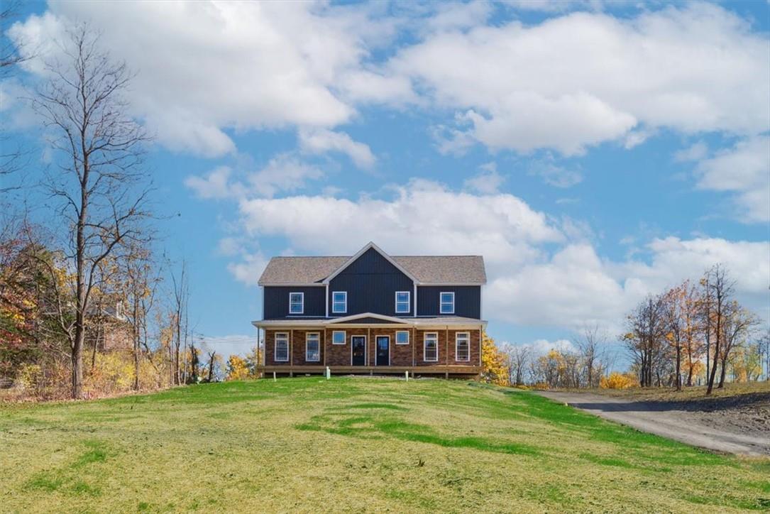 View of front of house with covered porch and a front yard