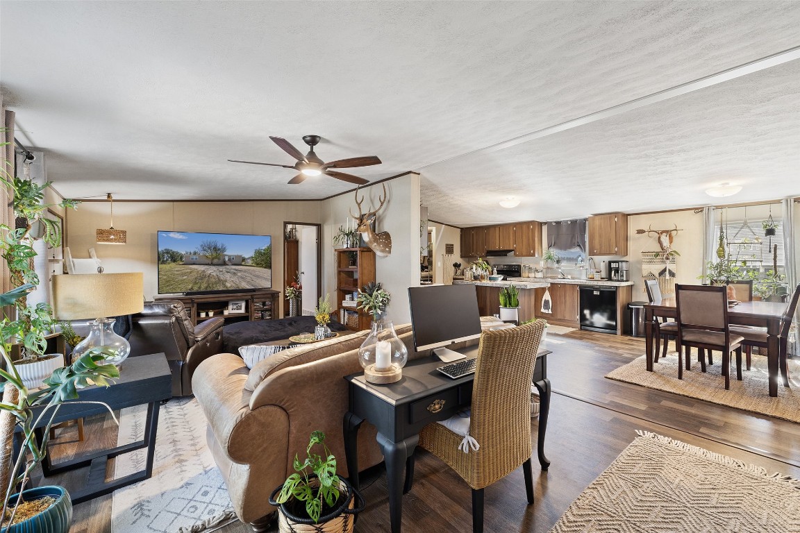 a living room with lots of furniture and view of kitchen