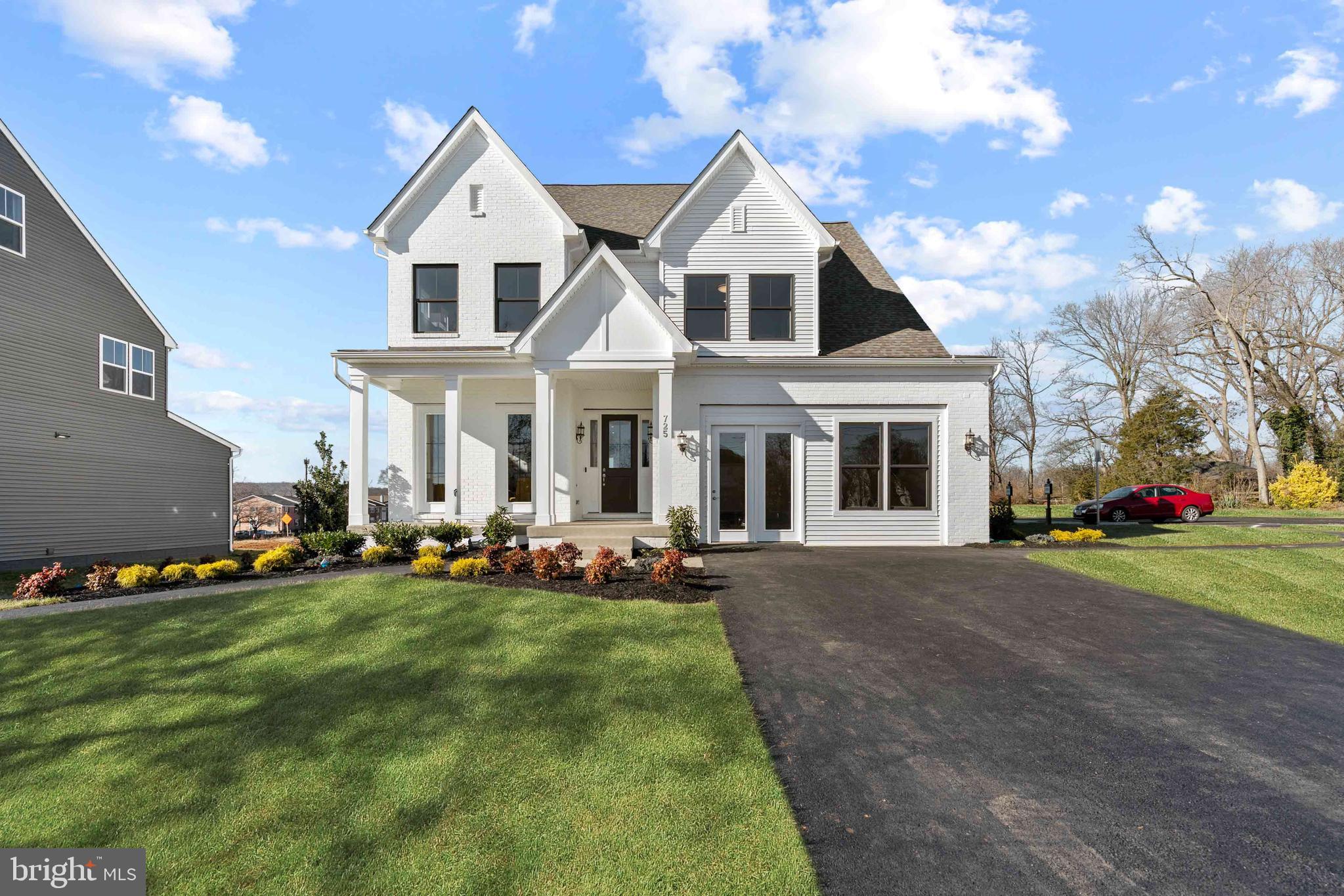 a front view of a house with a yard and trees