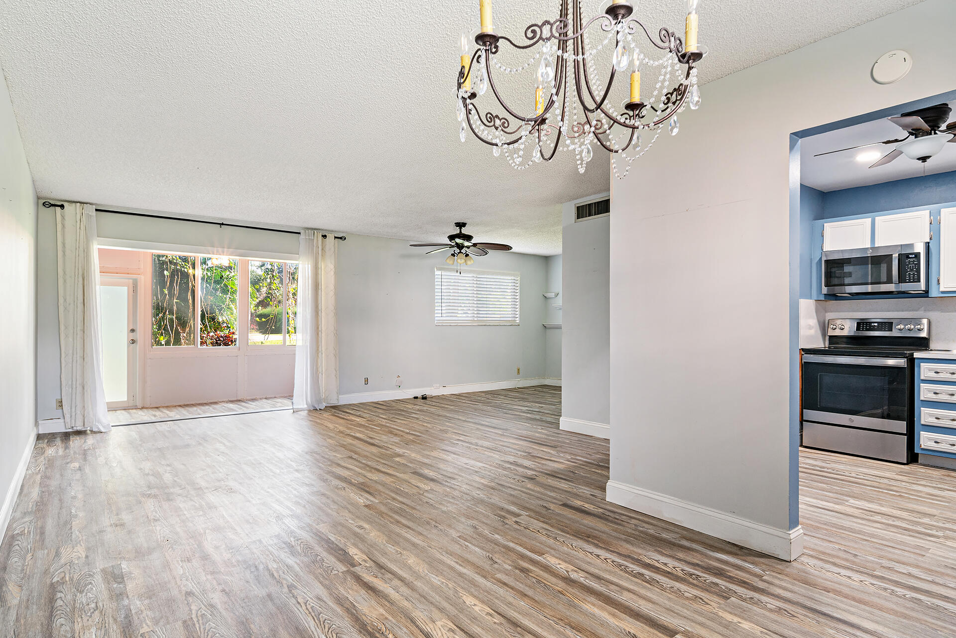 a view of empty room with wooden floor and window