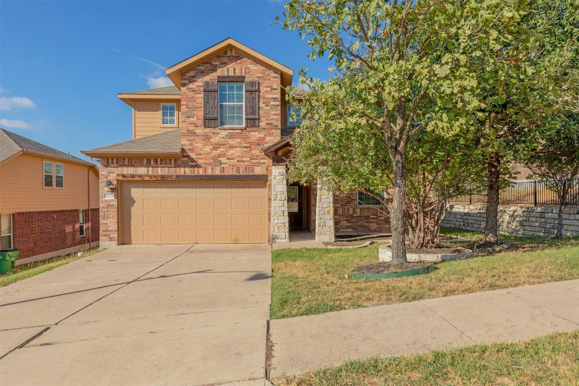 a front view of a house with a yard and garage