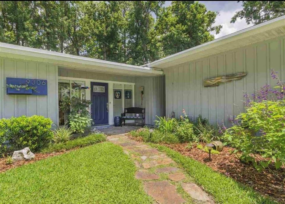 a view of a house with backyard and sitting area