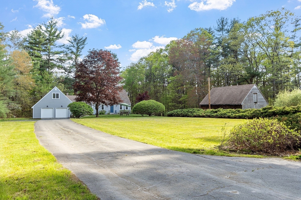 a front view of a house with a yard and trees