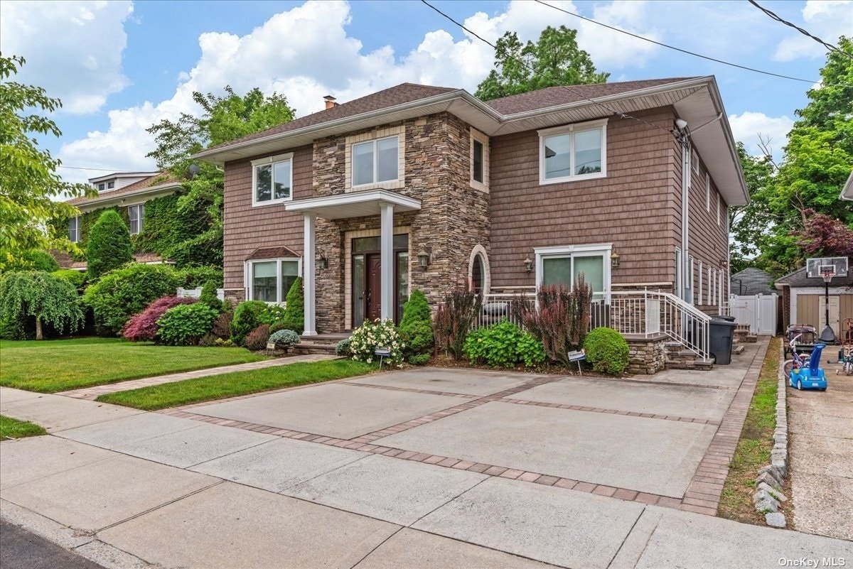 a front view of a house with a yard and potted plants