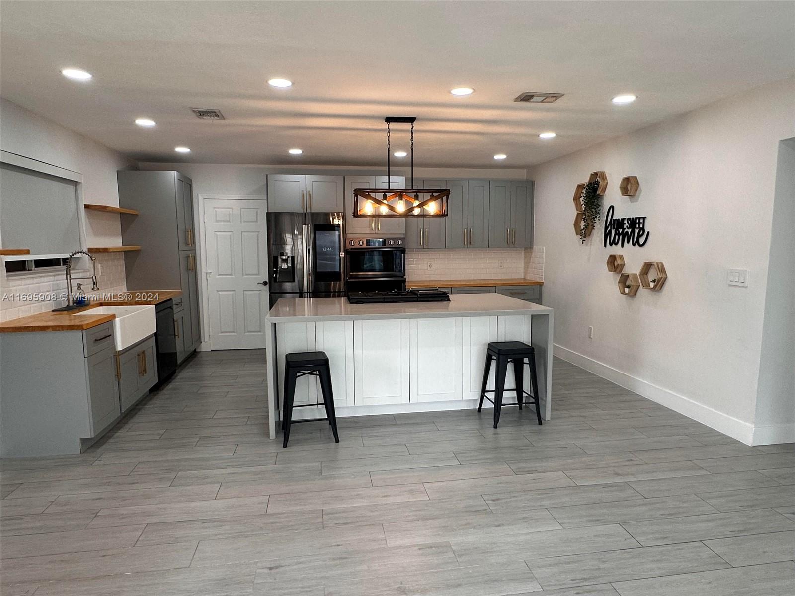 a kitchen with stainless steel appliances granite countertop a sink a stove and a wooden floors