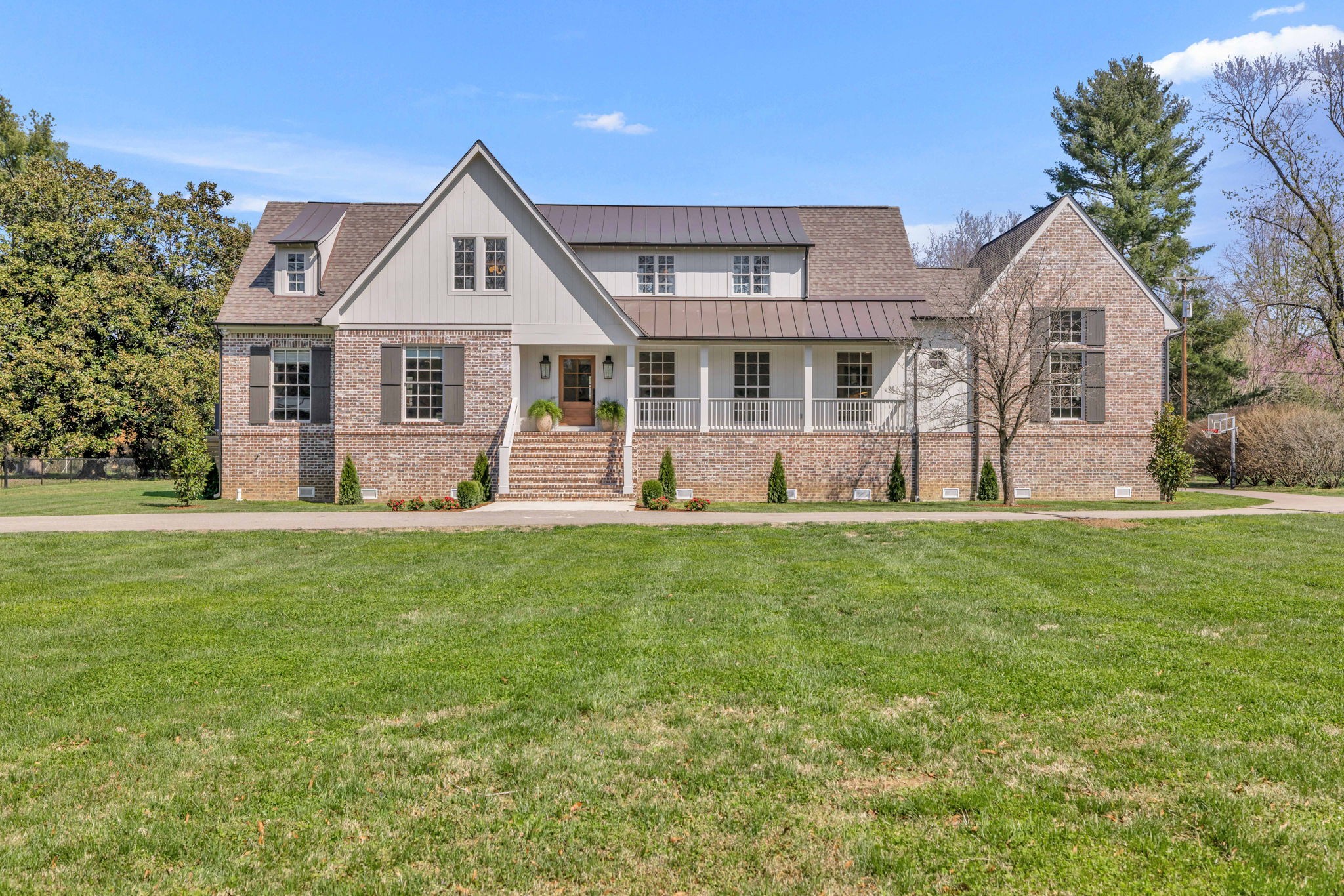 a front view of a house with a yard and green space