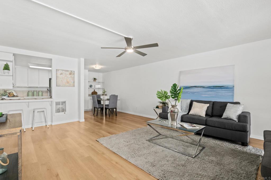 a living room with furniture and a dining table with kitchen view