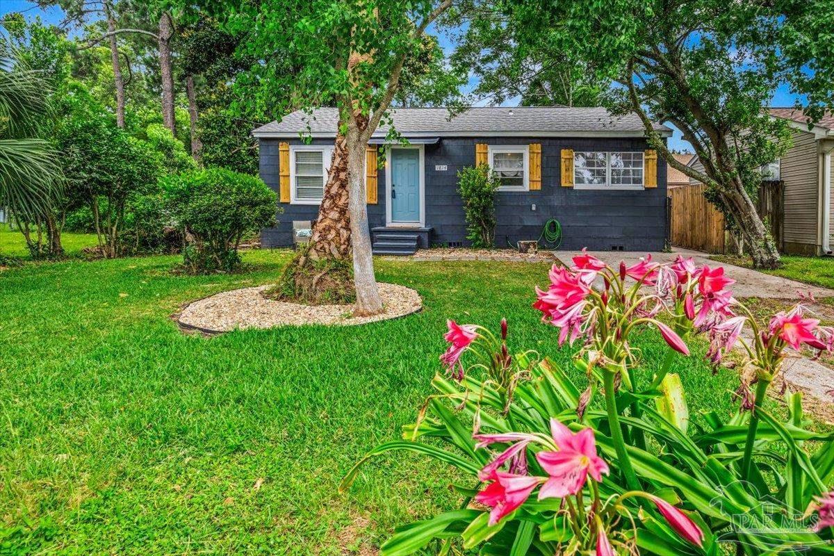 a front view of a house with a yard and fountain