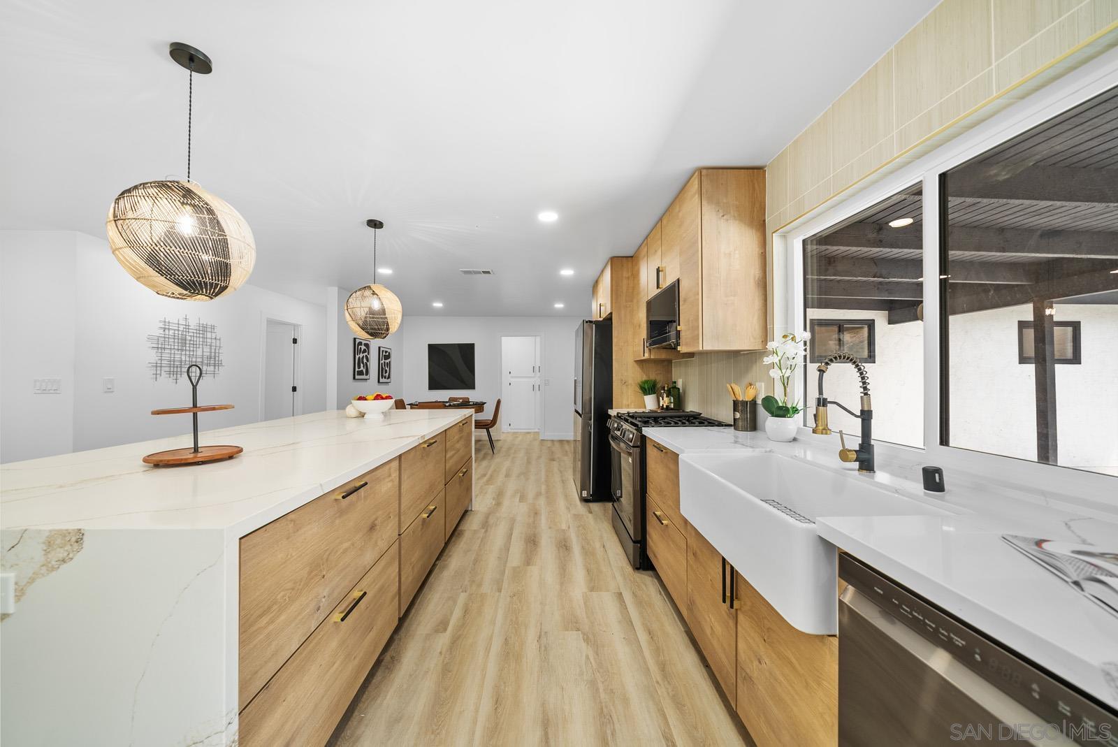 a large kitchen with kitchen island a large counter space a sink and stainless steel appliances