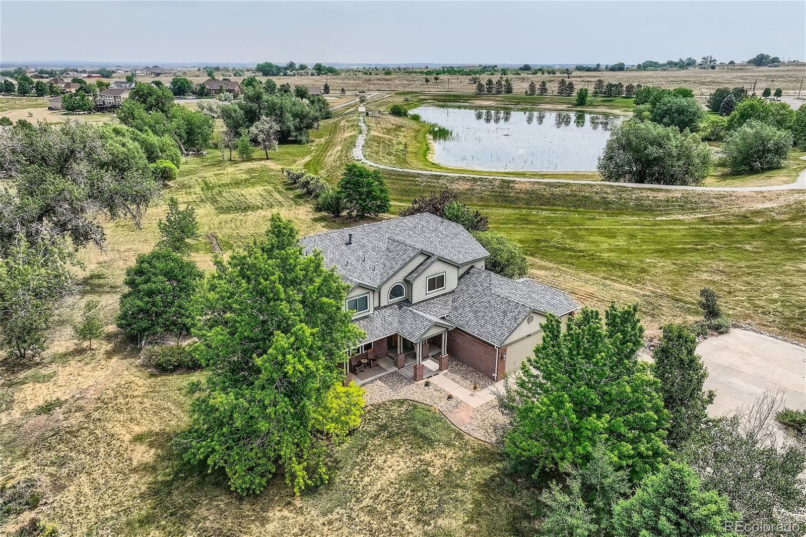 an aerial view of a house with a garden and lake view