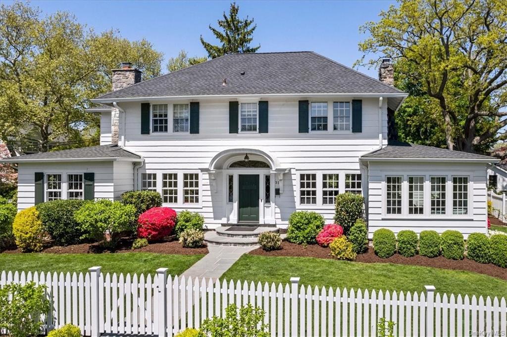 a front view of a house with a yard and potted plants