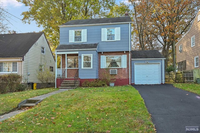 a front view of a house with a garden and yard