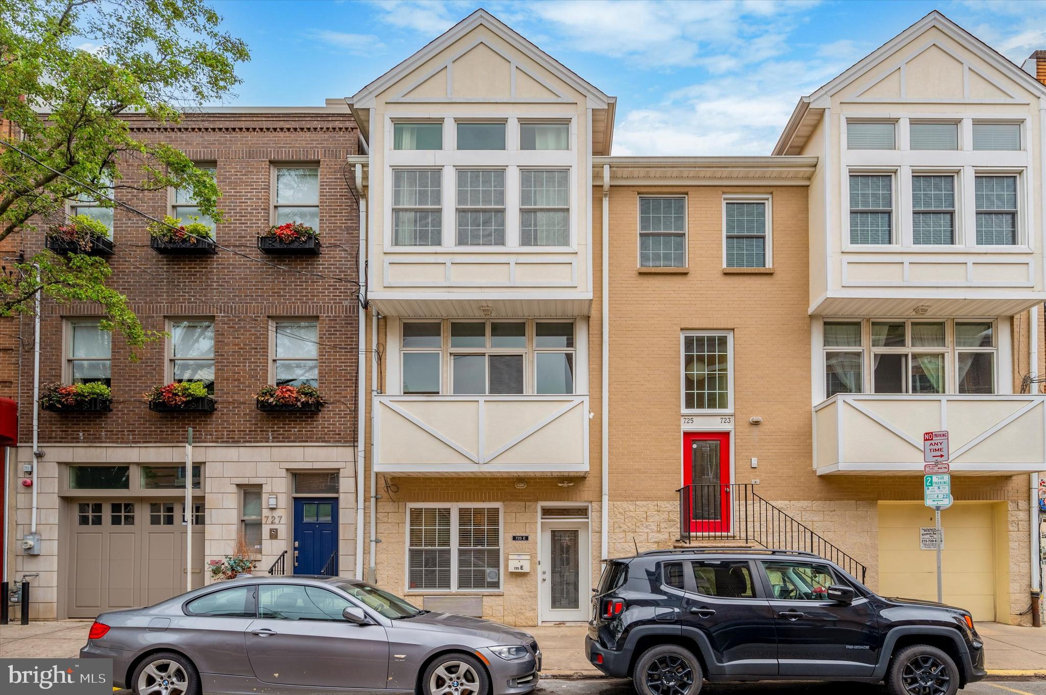 a front view of a residential apartment building with a cars parked in front of it