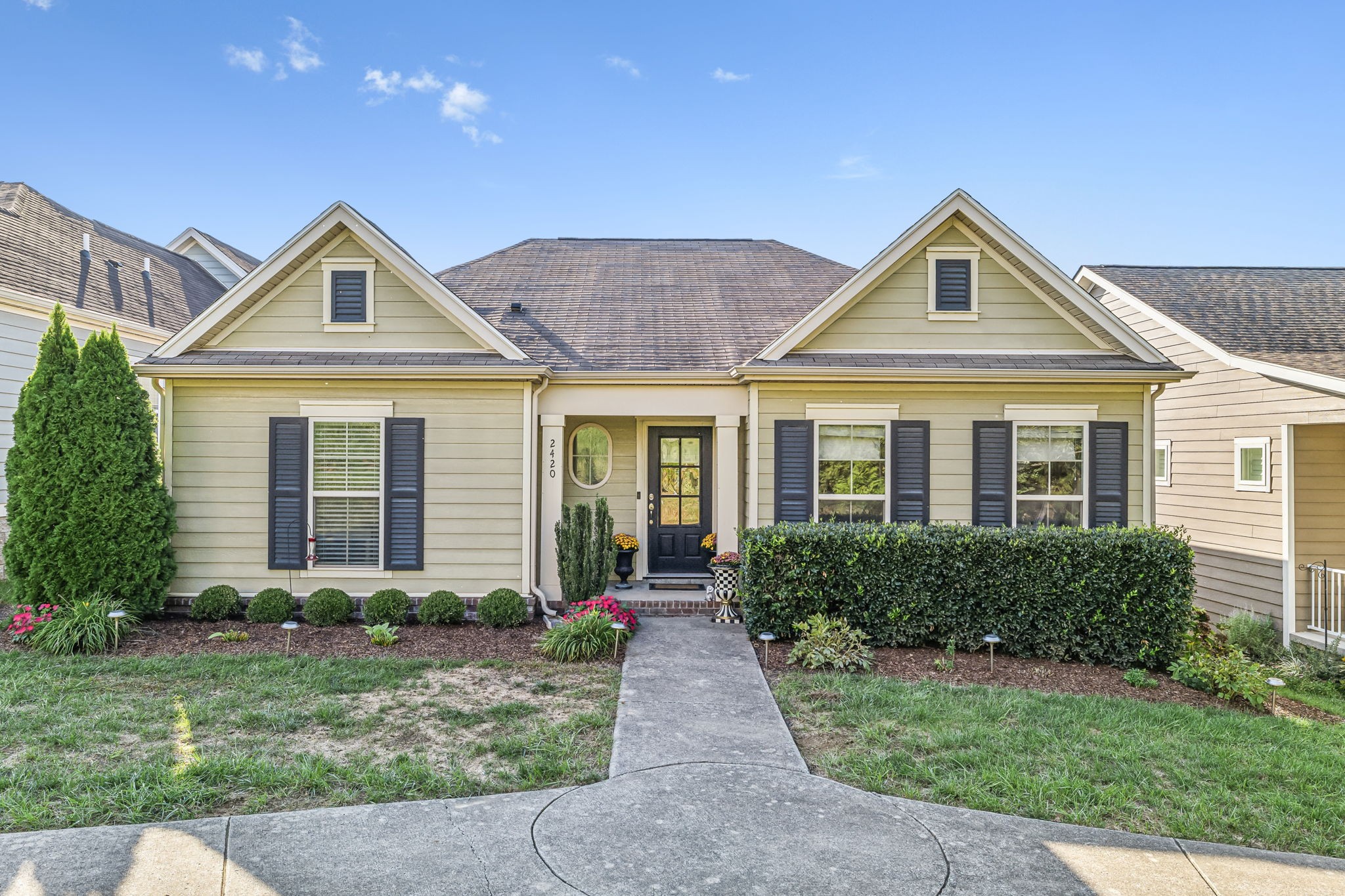 a front view of a house with yard and green space