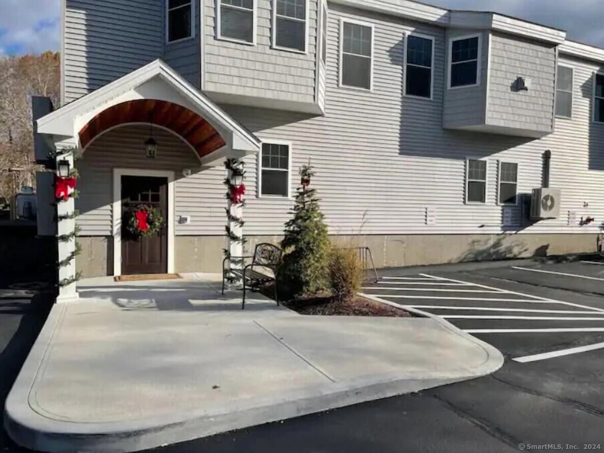 a view of a house with car parked on the road