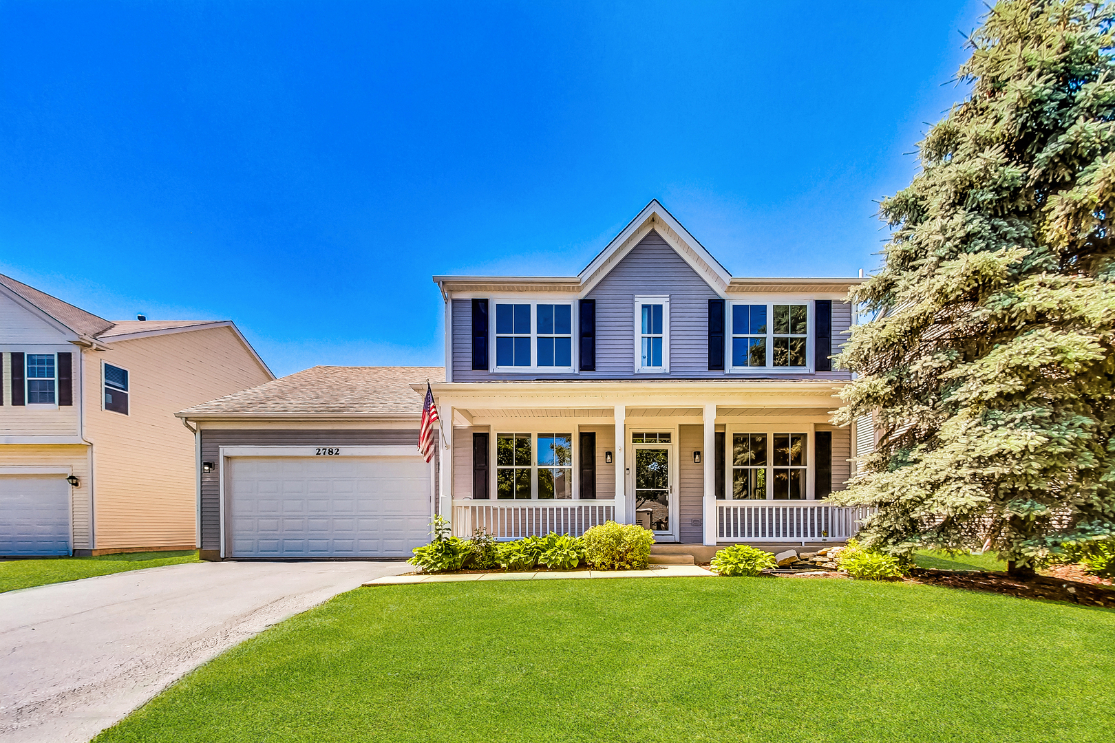 a front view of a house with a garden and yard