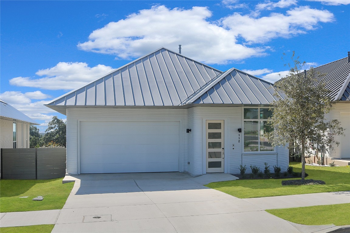 a front view of a house with a garden and garage