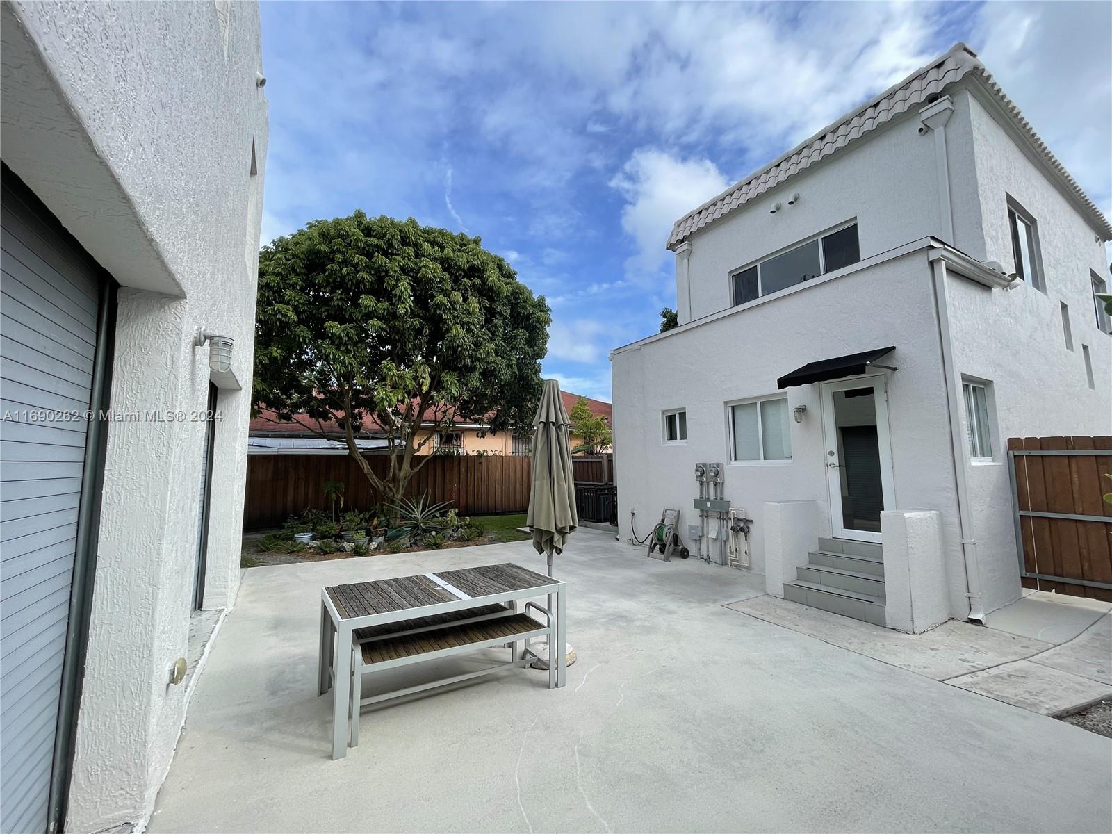 a backyard of a house with barbeque oven table and chairs