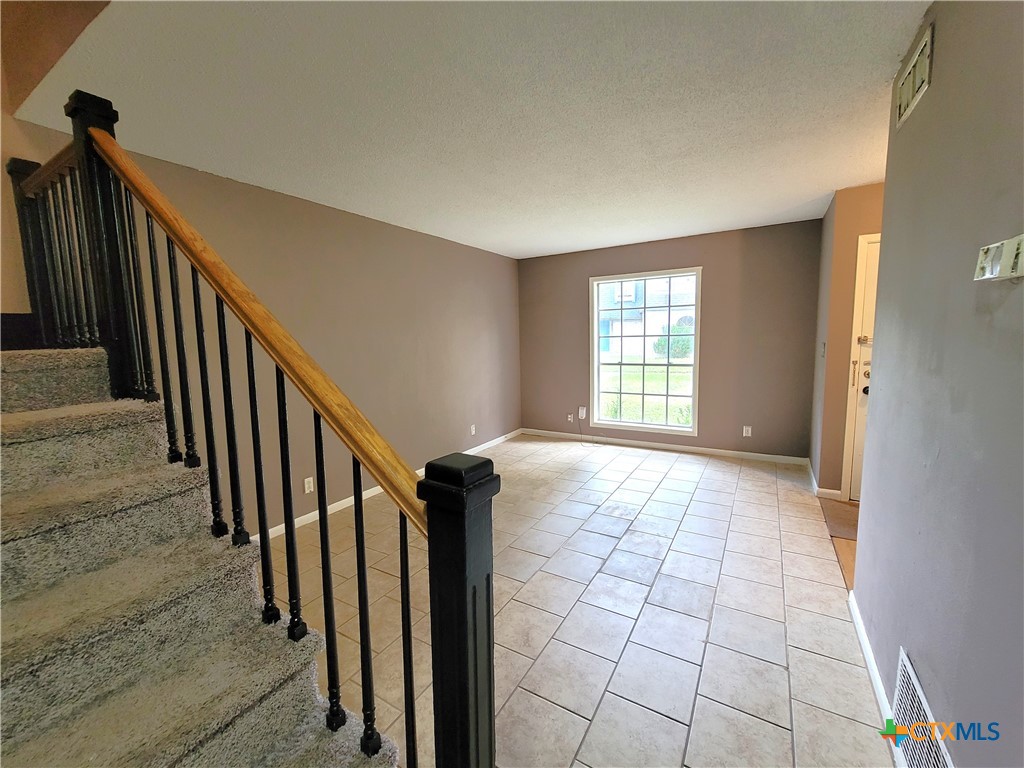 a view of an empty room and staircase