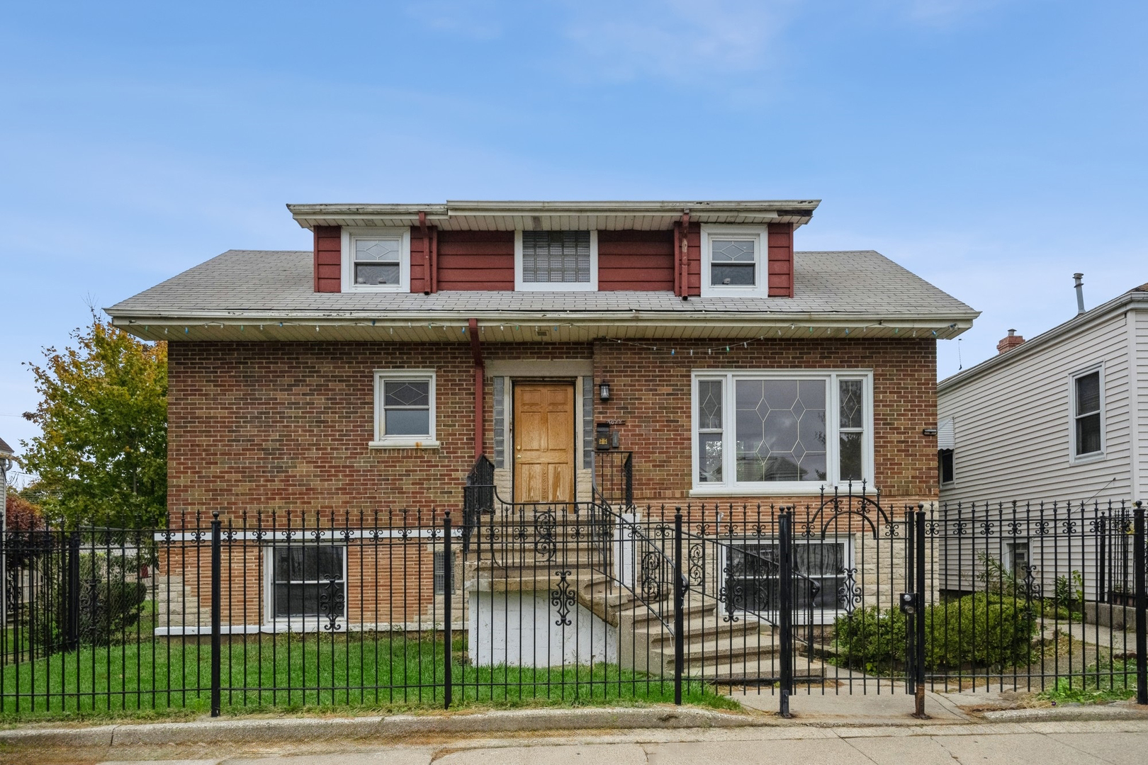 a front view of a house with iron fence