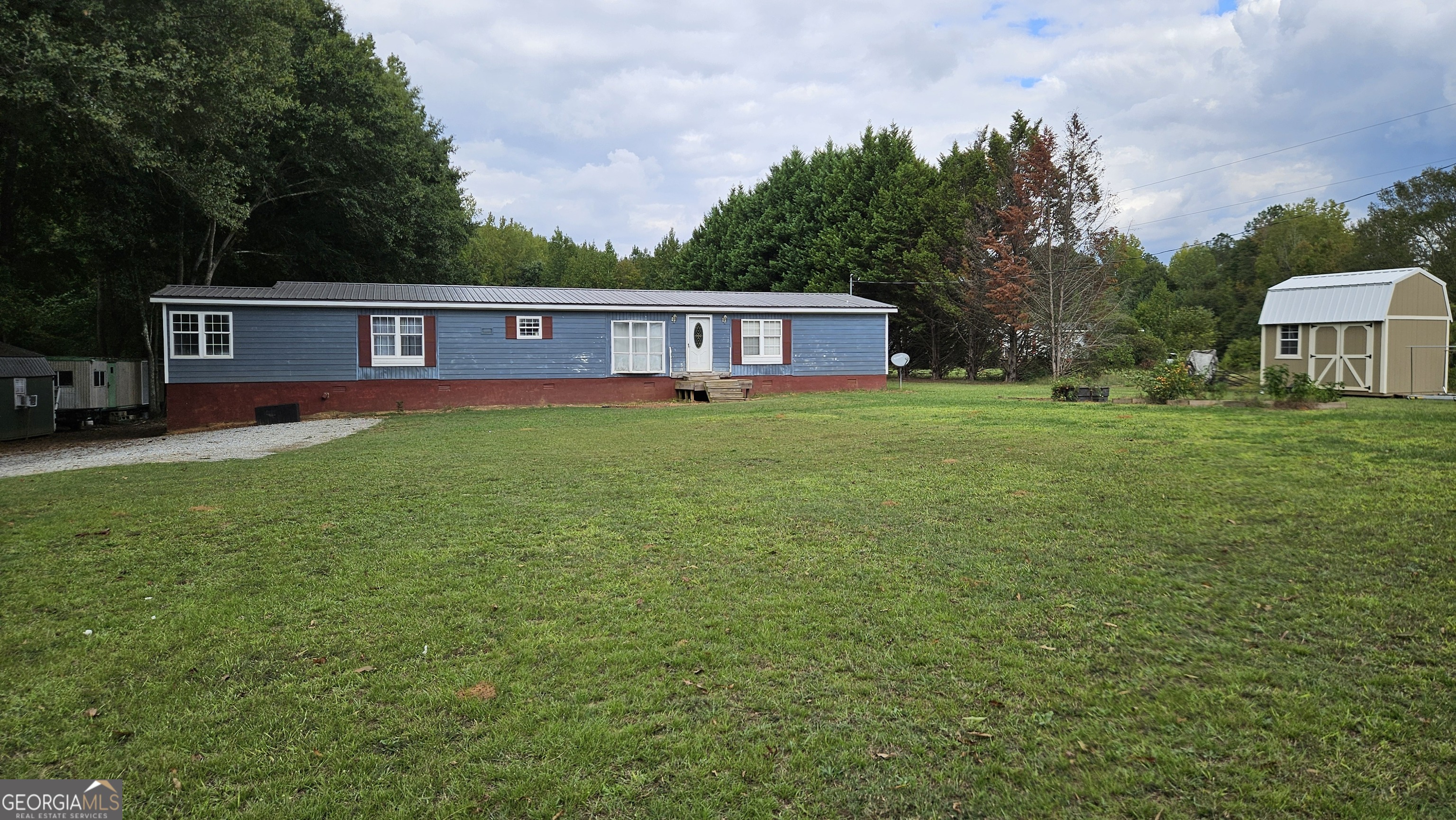 a view of a yard in front of a house with large tree